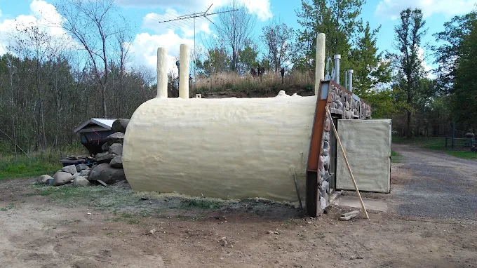 Exterior of an earth-bermed structure coated in spray foam insulation